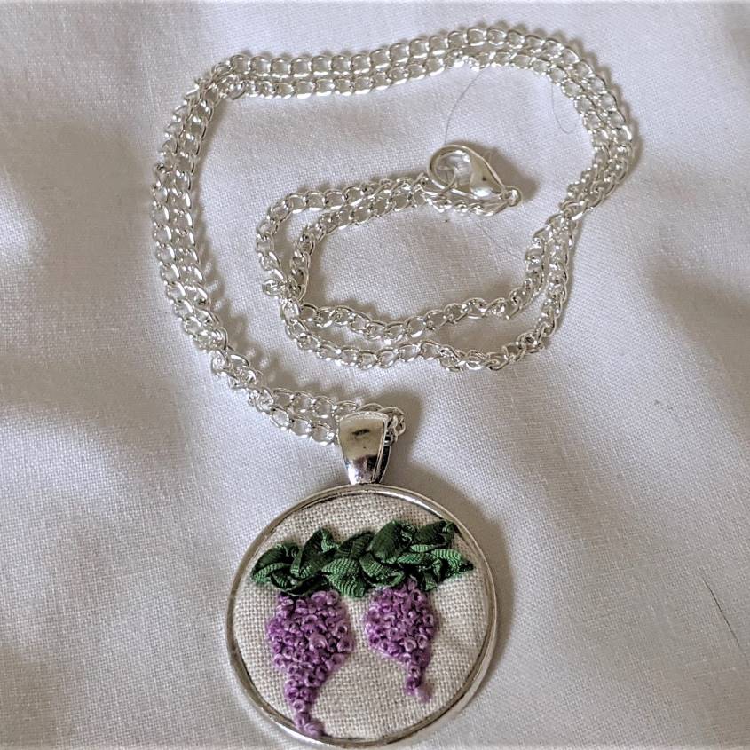 Round embroidered flower pendant