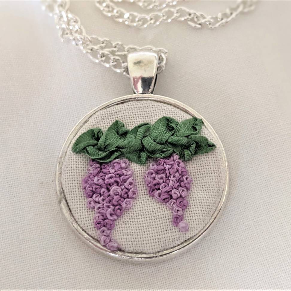 Round embroidered flower pendant