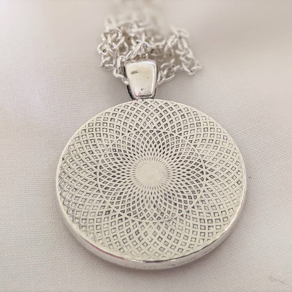 Round embroidered flower pendant