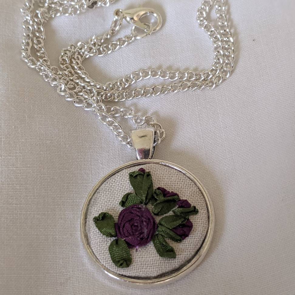 Round embroidered flower pendant