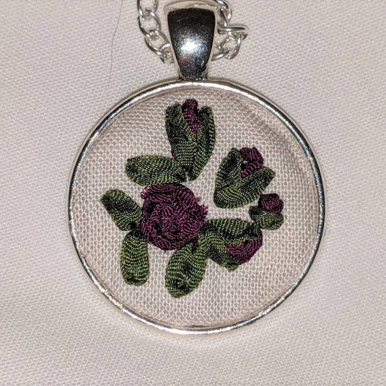 Round embroidered flower pendant
